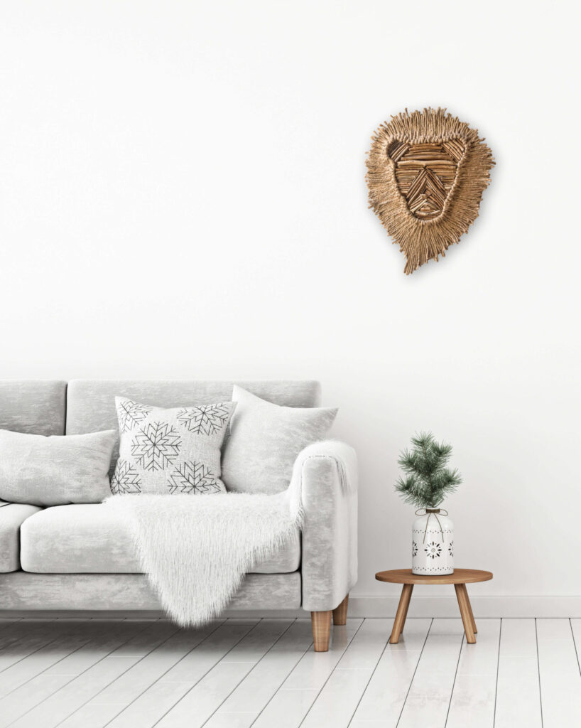 Silhouette de lion en bois flotté accrochée au mur au dessus d'une table basse et d'un canapé cosy blanc