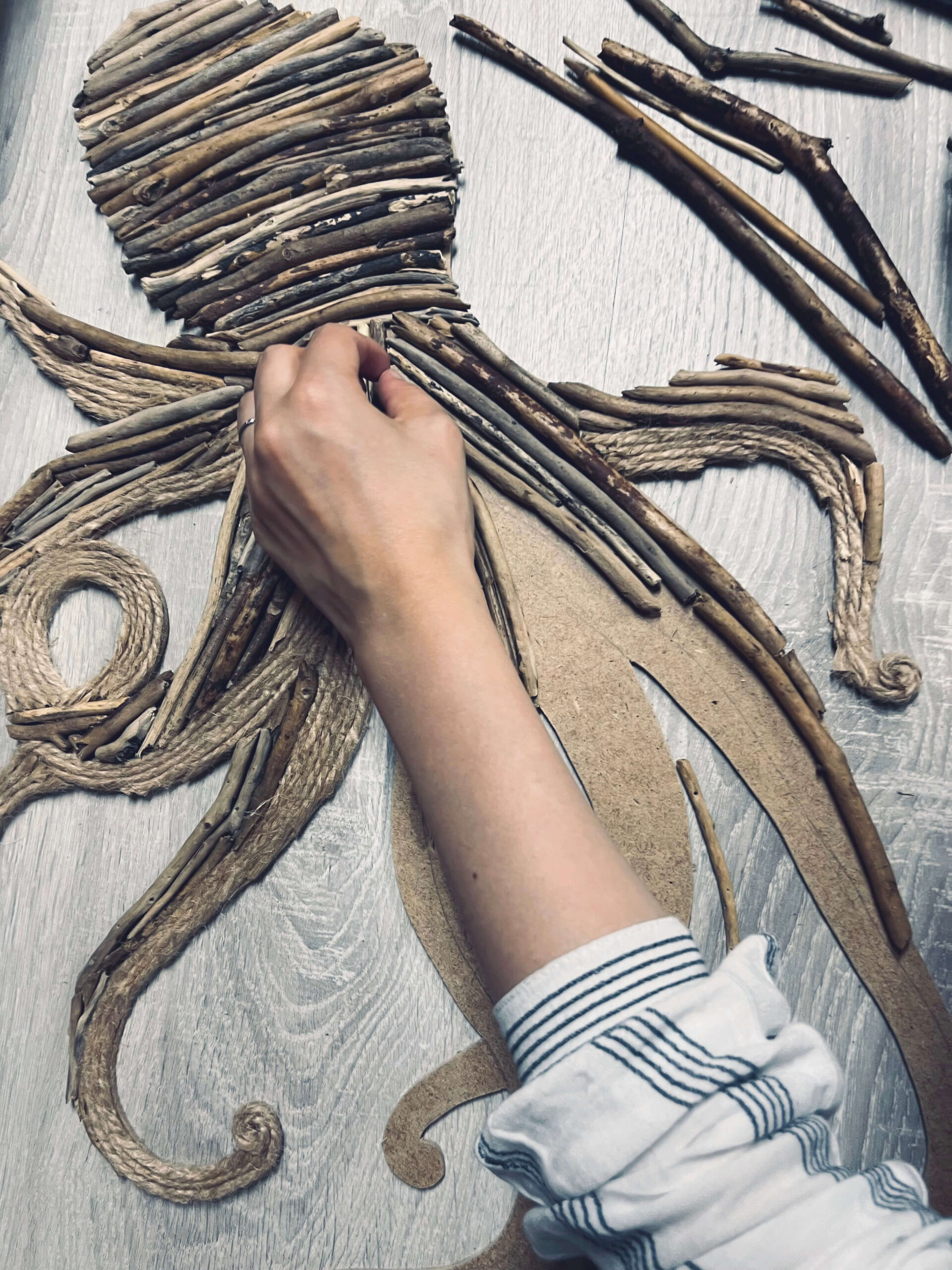 Assemblage de bois flotté sur la silhouette d'un octopus à la main